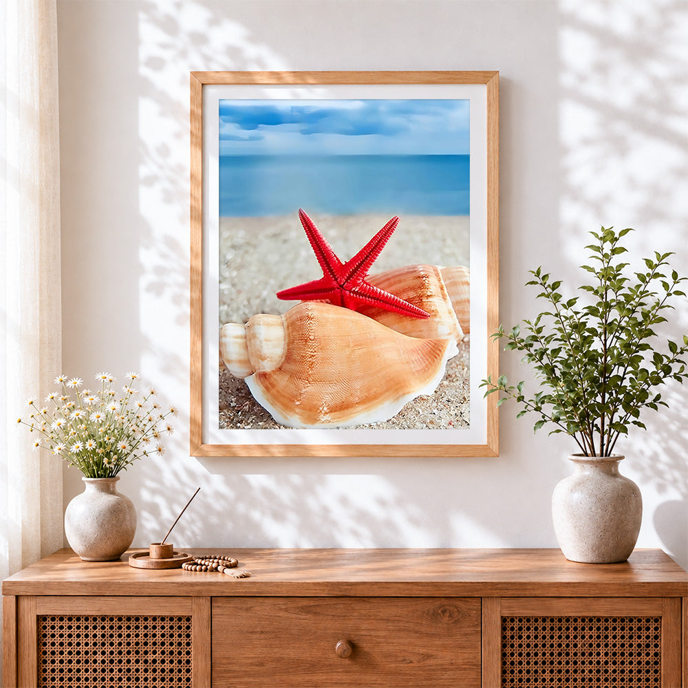 Finished red starfish and seashell on the beach cross stitch artwork displayed