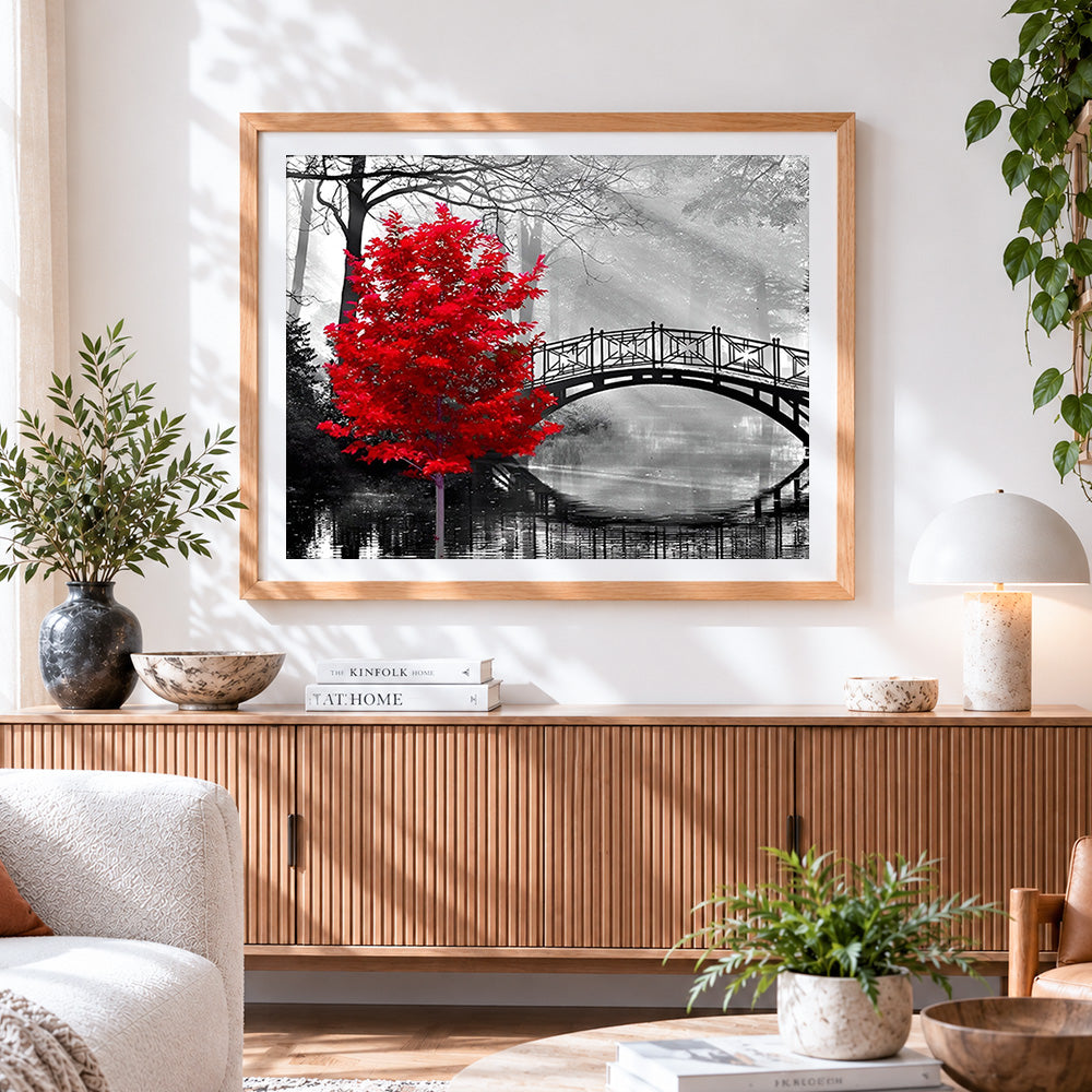 Finished red tree and bridge cross stitch artwork displayed