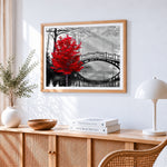 Red tree and bridge cross stitch artwork displayed on wall as home decor