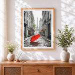 Finished red umbrella in a parisian street cross stitch artwork displayed