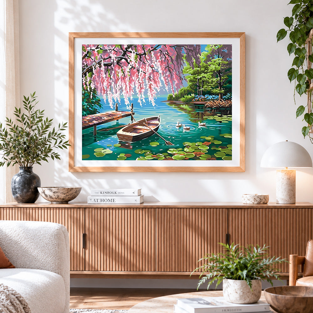 Finished rowboat and ducks on a lake with blossoms cross stitch artwork displayed