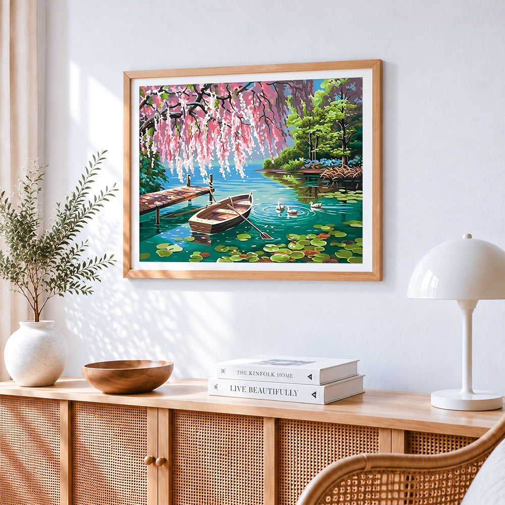 Rowboat and ducks on a lake with blossoms cross stitch artwork displayed on wall as home decor