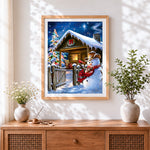 Finished rustic snowman by a snowy log cabin cross stitch artwork displayed