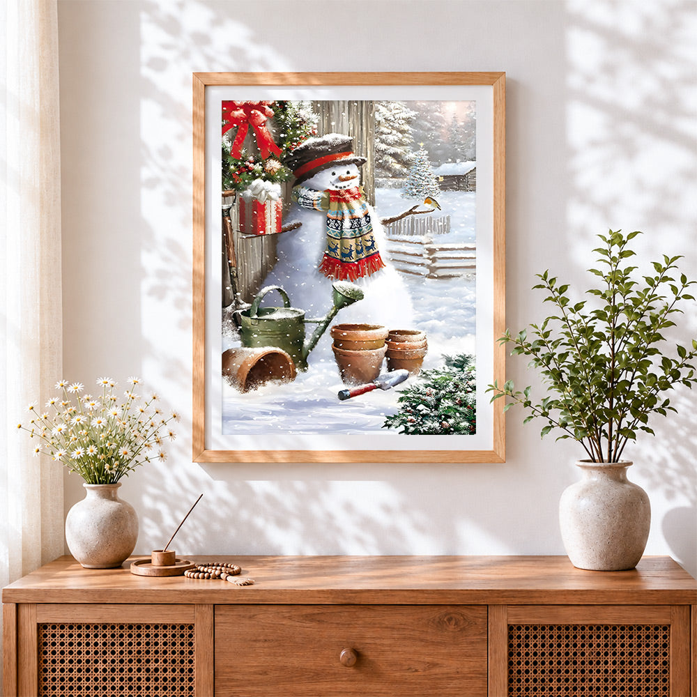 Finished rustic snowman, robin and gardening tools cross stitch artwork displayed