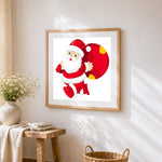Santa claus carrying a red gift sack cross stitch artwork displayed on wall as home decor