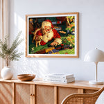 Santa claus playing with toy train cross stitch artwork displayed on wall as home decor