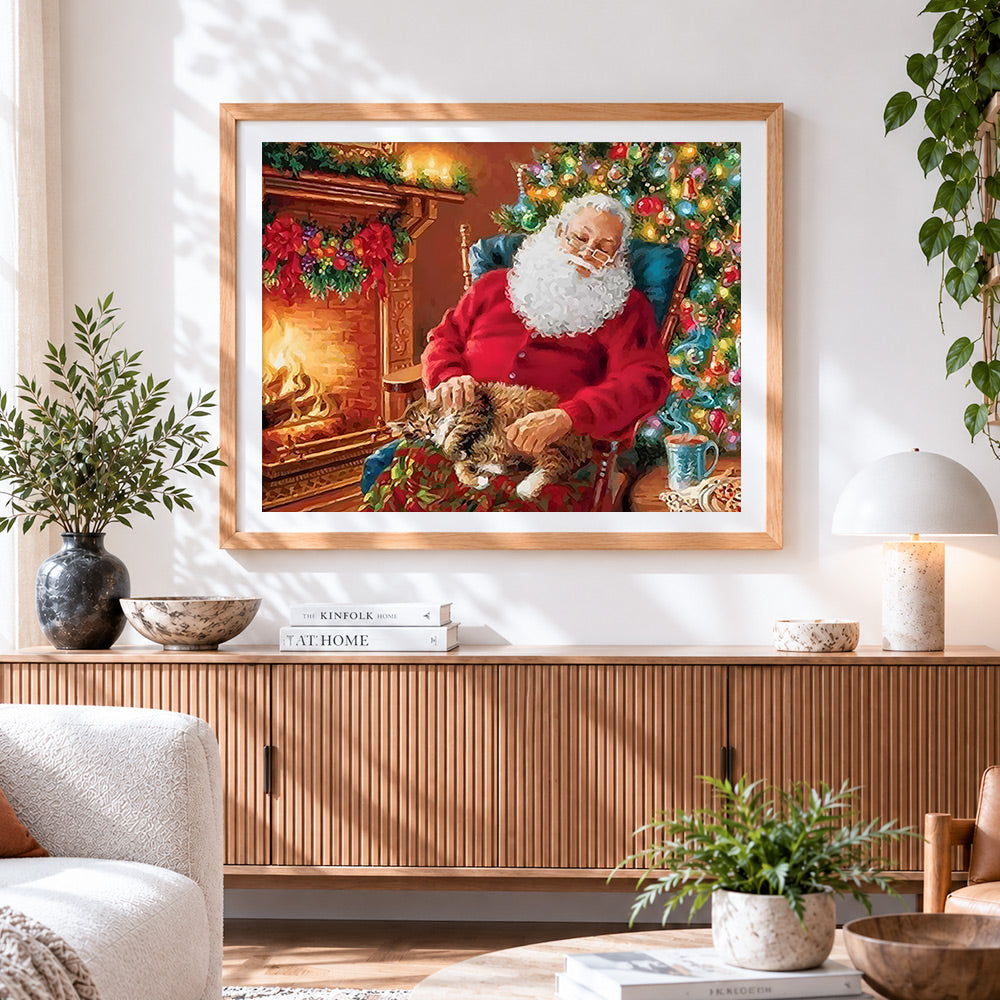 Finished santa claus relaxing by the fire with cat cross stitch artwork displayed