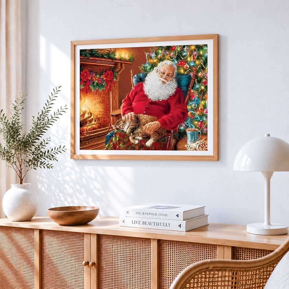 Santa claus relaxing by the fire with cat cross stitch artwork displayed on wall as home decor