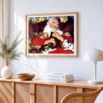 Santa cuddling puppies and kittens cross stitch artwork displayed on wall as home decor
