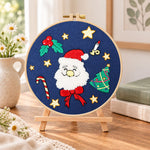 Santa face design embroidery kit finished hoop displayed on a wooden stand as cosy tabletop decor