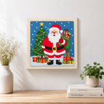 Finished santa holding gift sack artwork displayed on a wall