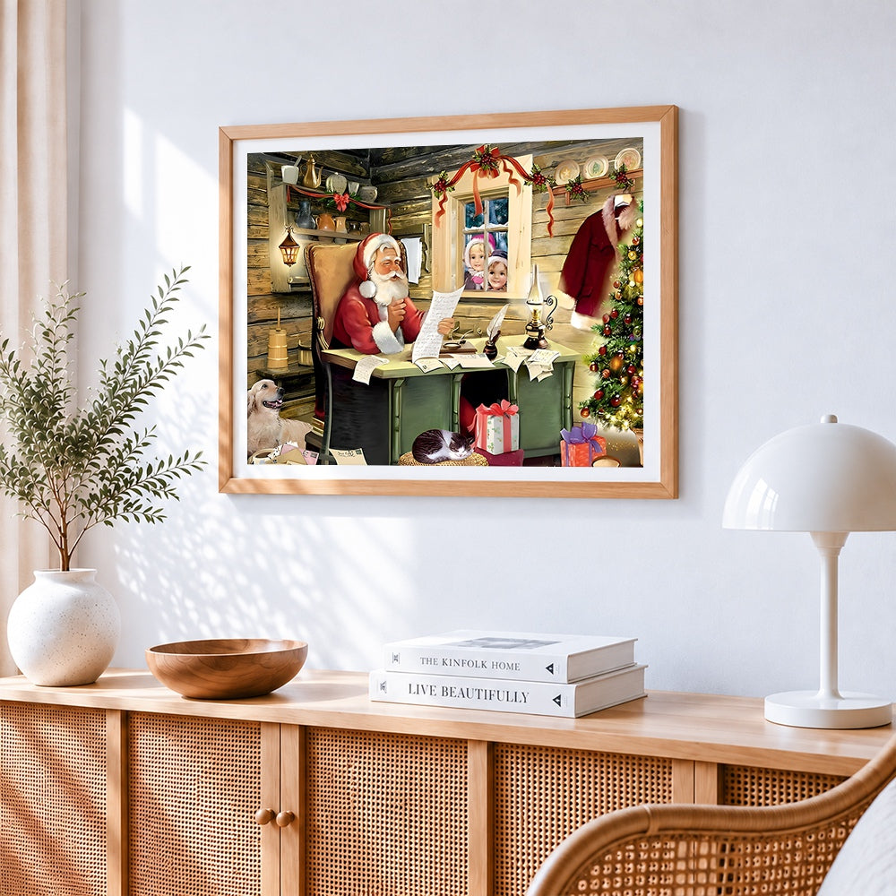 Santa reading letters in cosy log cabin cross stitch artwork displayed on wall as home decor