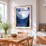 Santa's sleigh flying across a full moon silhouette cross stitch artwork displayed on wall as home decor