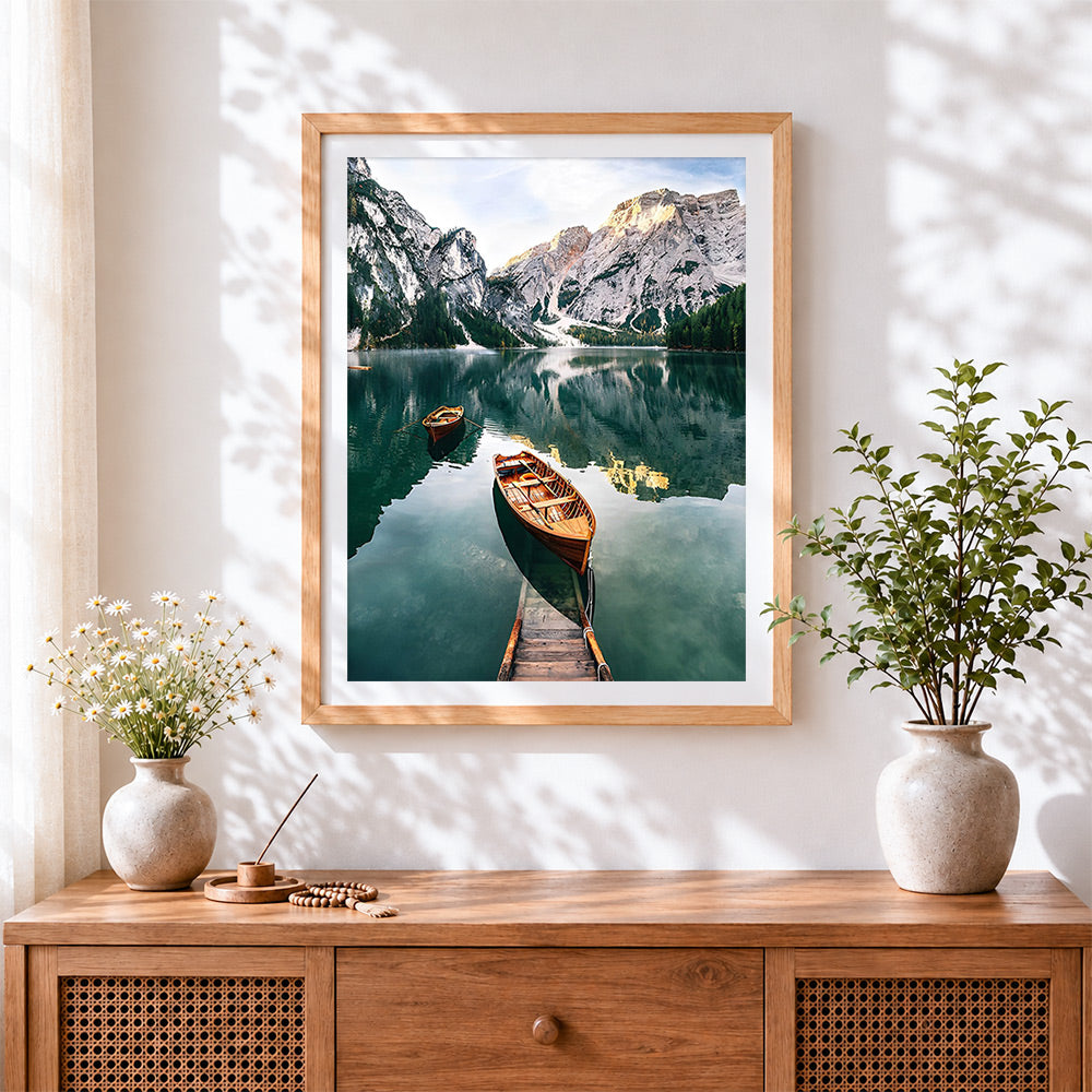 Finished serene alpine lake and wooden boats cross stitch artwork displayed