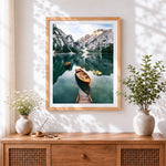 Finished serene alpine lake and wooden boats cross stitch artwork displayed