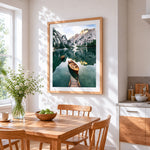 Serene alpine lake and wooden boats cross stitch artwork displayed on wall as home decor