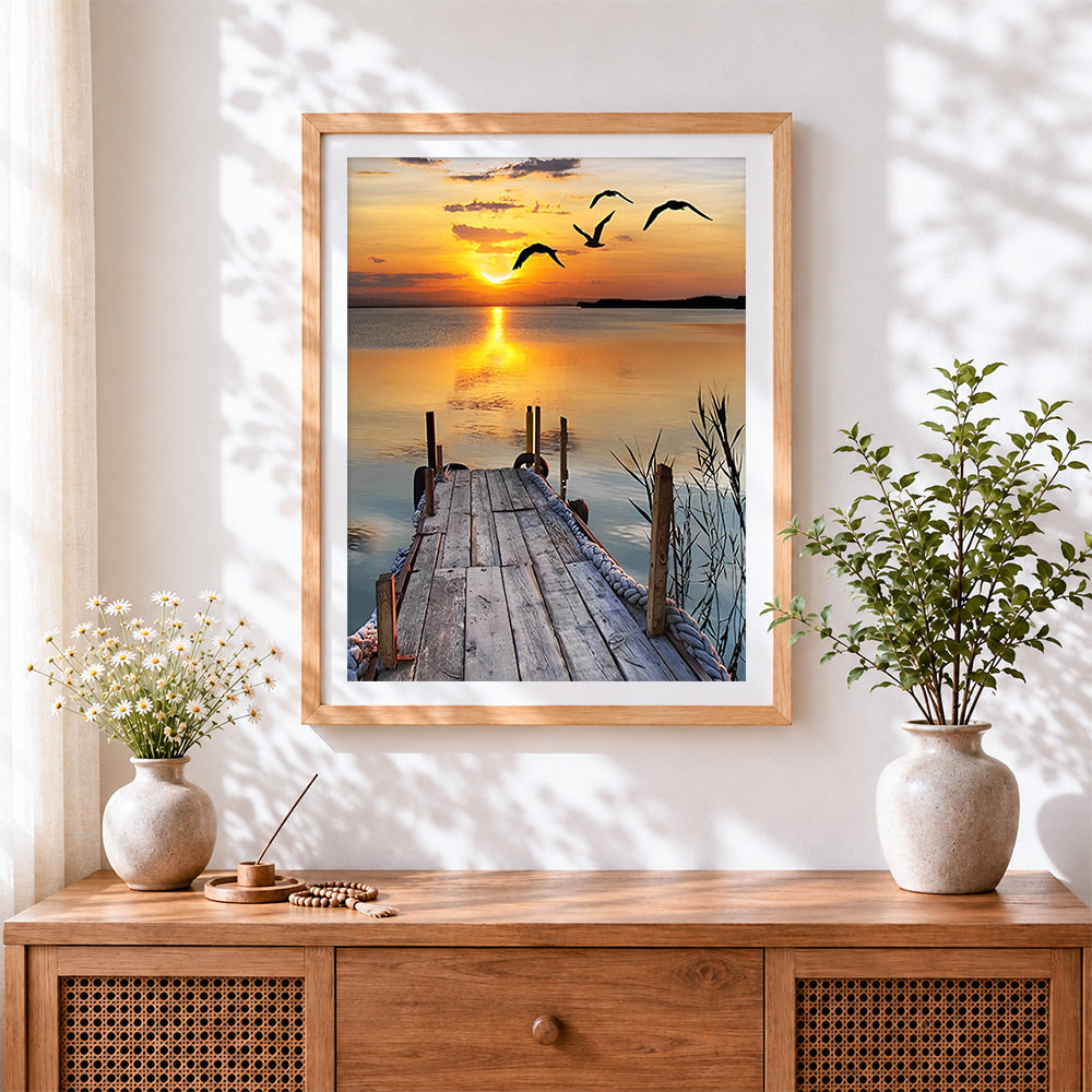 Finished serene wooden pier sunset cross stitch artwork displayed