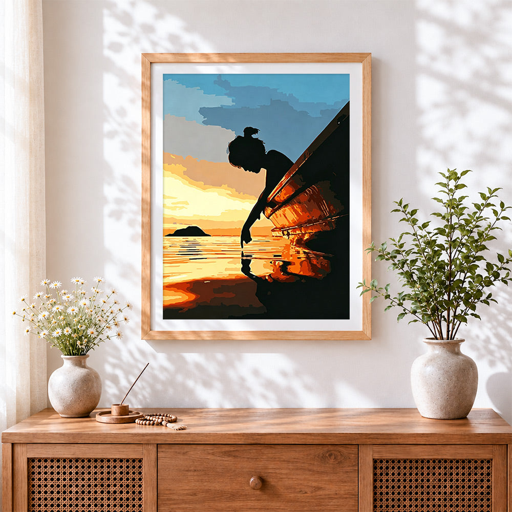 Finished silhouette of a girl by a boat at sunset cross stitch artwork displayed