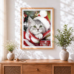 Finished silver tabby cat in a santa hat cross stitch artwork displayed