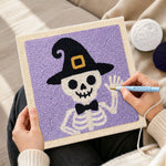 Creating handmade skeleton in witch hat punch needle artwork