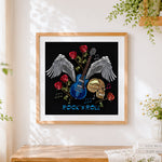 Finished skull guitar and wings cross stitch artwork displayed