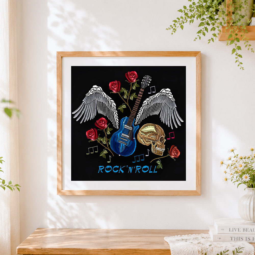 Finished skull guitar and wings cross stitch artwork displayed