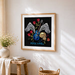 Skull guitar and wings cross stitch artwork displayed on wall as home decor