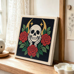 Skull with red roses punch needle artwork displayed on a table