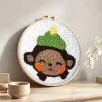Smiling little monkey punch needle artwork displayed on a table