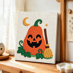 Smiling pumpkin with broom punch needle artwork displayed on a table