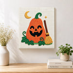 Finished smiling pumpkin with broom artwork displayed on a wall