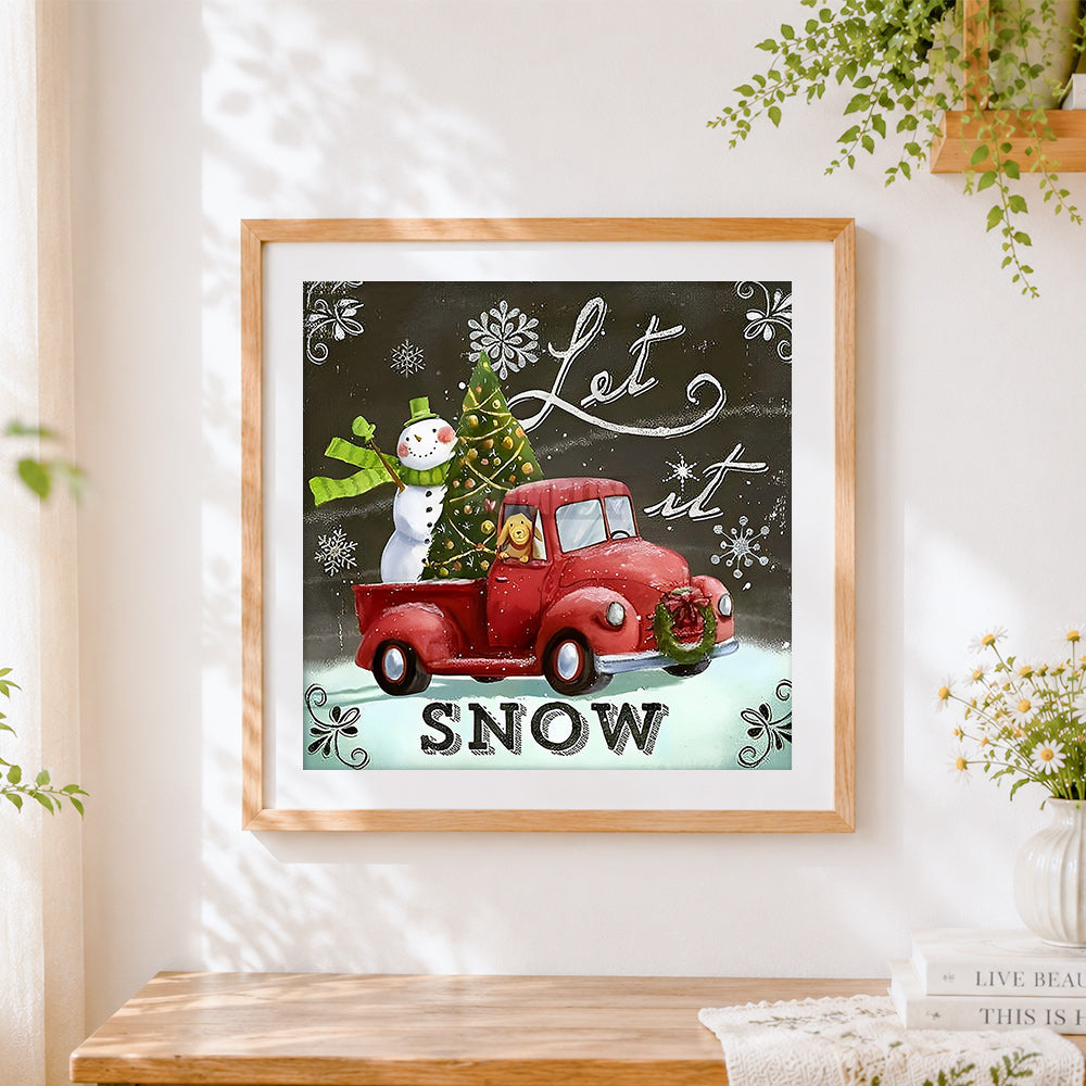 Finished snowman and red truck cross stitch artwork displayed