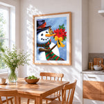 Snowman holding poinsettia cross stitch artwork displayed on wall as home decor