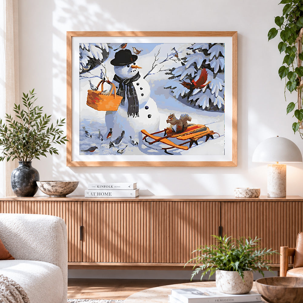Finished snowman with basket and garden birds cross stitch artwork displayed