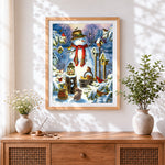 Finished snowman with birdhouses and woodland creatures cross stitch artwork displayed