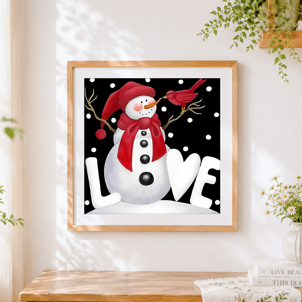 Finished snowman with red bird cross stitch artwork displayed