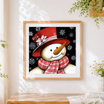 Finished snowman with red hat and snowflakes cross stitch artwork displayed