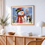 Snowman with robin and cat cross stitch artwork displayed on wall as home decor