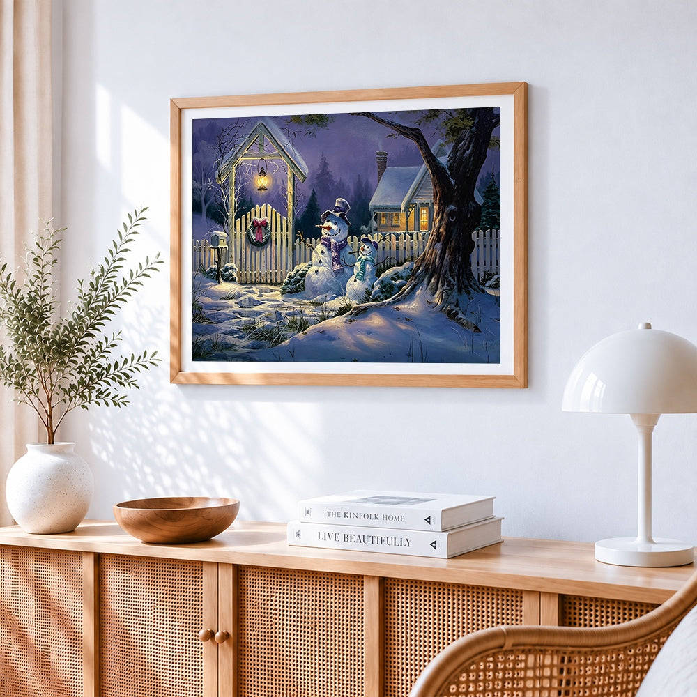 Snowmen by a fence at night cross stitch artwork displayed on wall as home decor