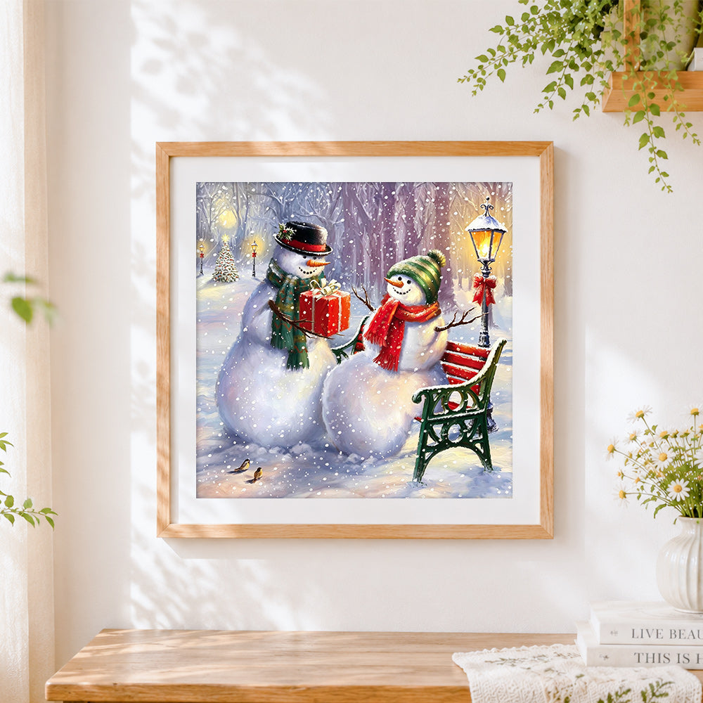 Finished snowmen couple with gift on a bench cross stitch artwork displayed