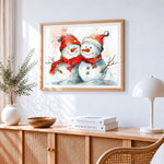Snowmen with red scarves cross stitch artwork displayed on wall as home decor
