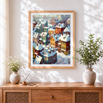 Finished snowy colourful village rooftops cross stitch artwork displayed