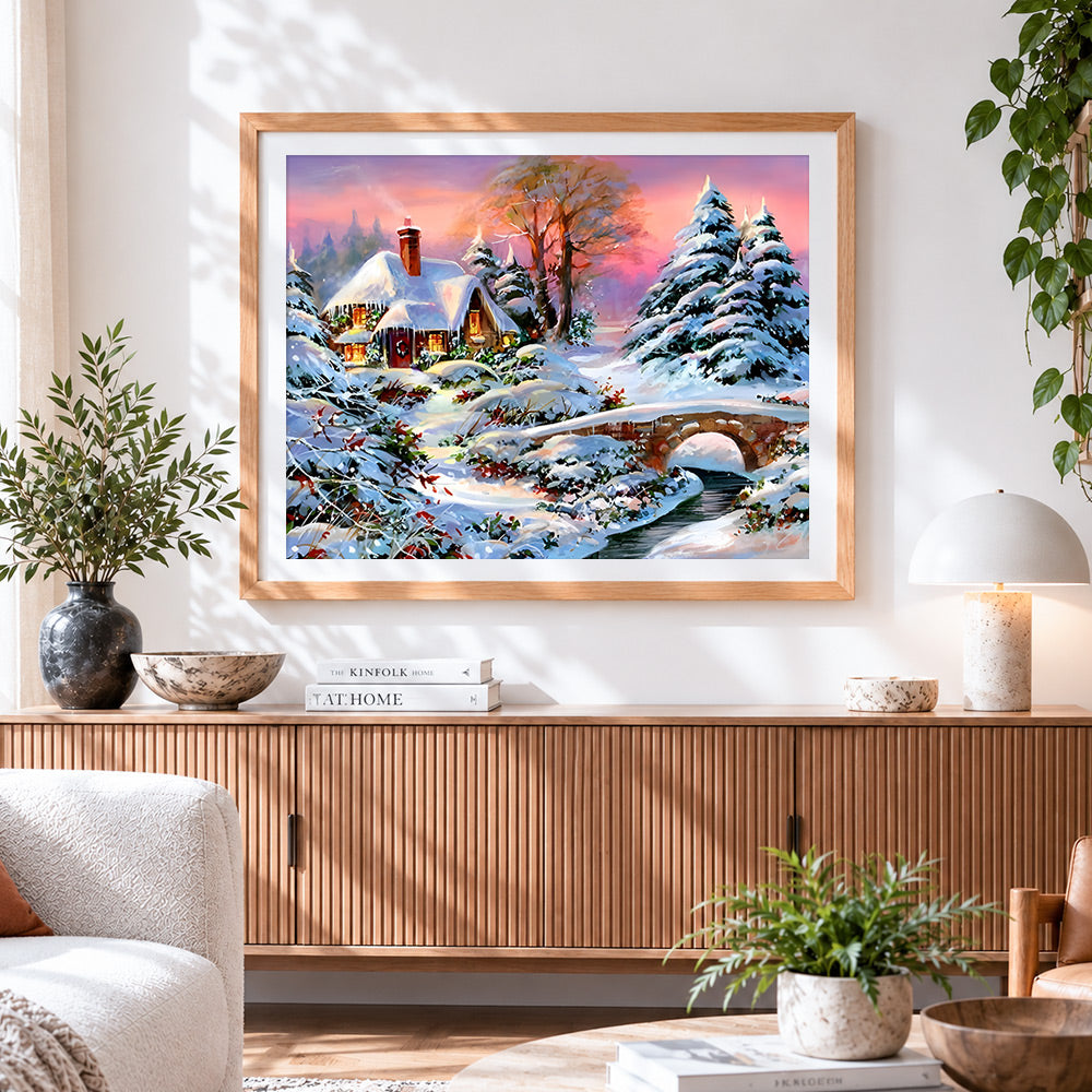 Finished snowy cottage and bridge at sunset cross stitch artwork displayed