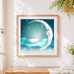 Finished snowy crescent moon cross stitch artwork displayed
