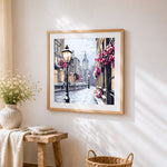 Snowy european street cross stitch artwork displayed on wall as home decor