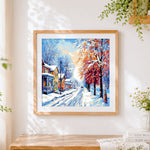 Finished snowy european street with trees cross stitch artwork displayed