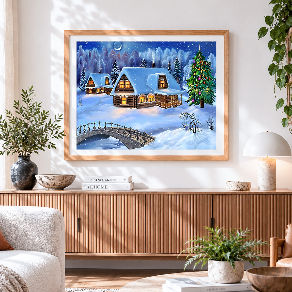 Finished snowy log cabins and christmas tree in winter forest cross stitch artwork displayed