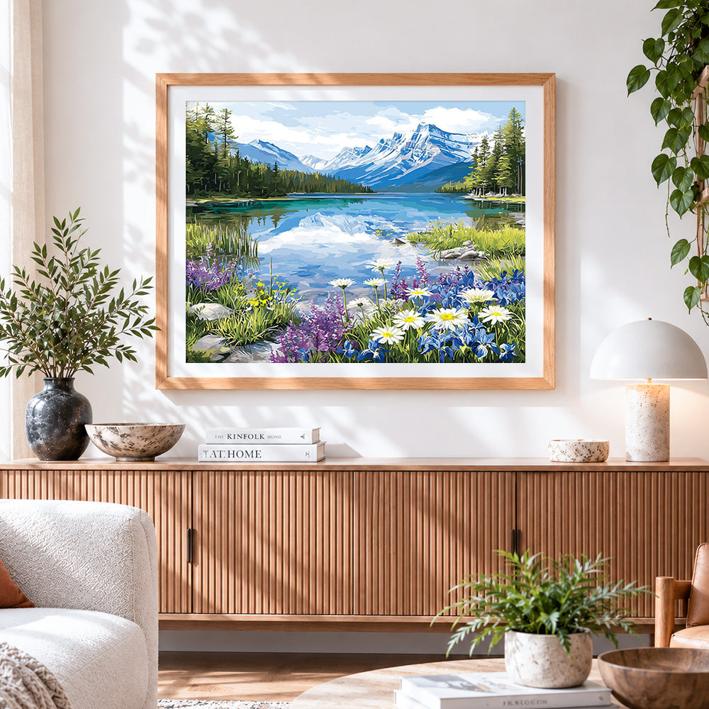Finished snowy mountain lake and wildflowers cross stitch artwork displayed