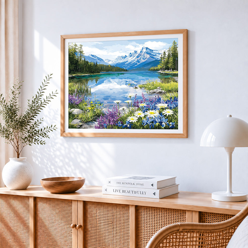 Snowy mountain lake and wildflowers cross stitch artwork displayed on wall as home decor