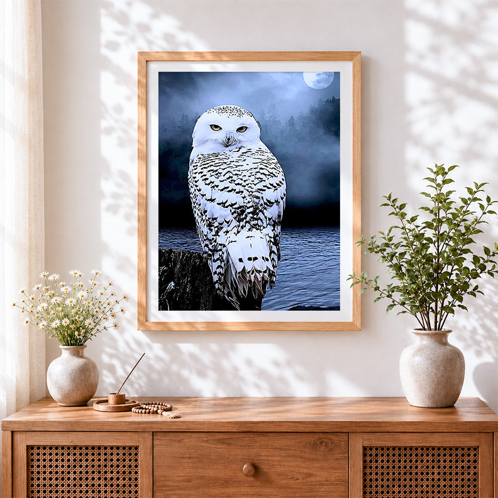 Finished snowy owl and full moon cross stitch artwork displayed